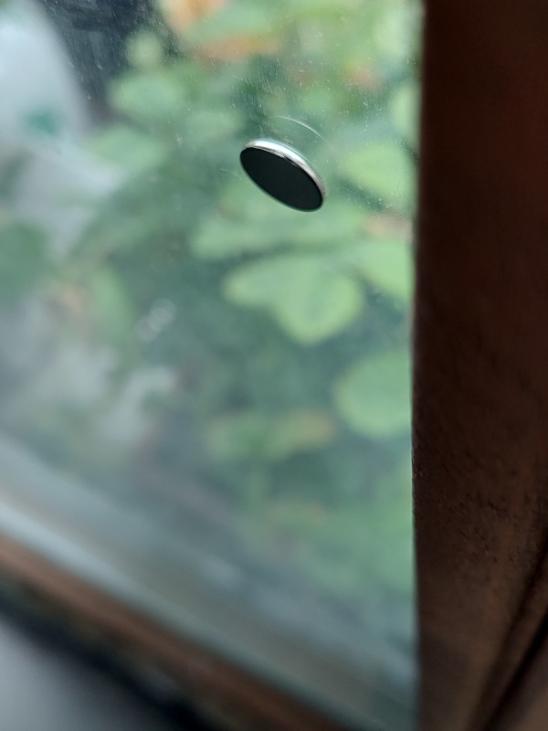 Round magnet stuck on window glass
